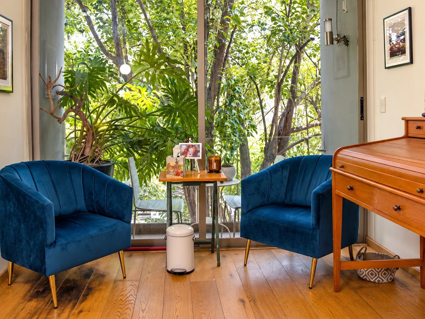 El consultorio de Narvarte: dos sillones azules enfrentados junto a un ventanal que da a un jardín, con una mesa pequeña en medio.